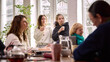 © master1305 - Women listening with interest during creative office meeting. Concept of attentive teamwork session, collaborative discussion process, inclusive workplace culture, professional development.