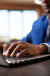 © DC Studio - Hands of startup employee on keyboard, working on laptop at modern desk. Closeup of black man typing on digital device to update financial analysis data for company project in office.