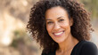 © Kateryna Arkhypova - Portrait smiling African American individual curly hair park, mixed-race smiling AI generated, outdoor happiness moment, diverse adult representation, with copy space