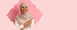 © Prostock-studio - A woman with a hijab is smiling and pointing to her left. She is in front of a pink background. This collage has unique shapes and colors that draw attention to her expression.