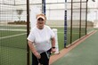 © Angelov - mature woman playing padel on outdoor court.