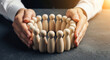 © Kamran - Business executive hands encircling wooden team figures perfect for corporate staff protection and safe human resources