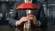 © Kamran - Businessman protecting group of figures with red umbrella perfect for corporate staff insurance and employee care strategy