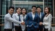 © Nathan - Group of Young Professionals Shaking Hands and Celebrating Success in Modern Office Environment