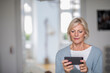 © Westend61 - Portrait of senior woman at home looking at cell phone