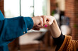 © DC Studio - Closeup of hands exchanging fist bump in office, symbolizing unity and cooperation between partners. Two professional individuals making hand gestures, representing successful business collaboration.