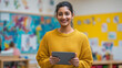 © INSPIRIA.K - Kindergarten teacher holding tablet in classroom. Young indian woman educator using digital device for lesson planning. Early childhood education technology and school environment concept.