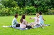 © narong - Little Asian girl run and go to hug grandfather who sit with her mother and father in public park during holiday with day light.