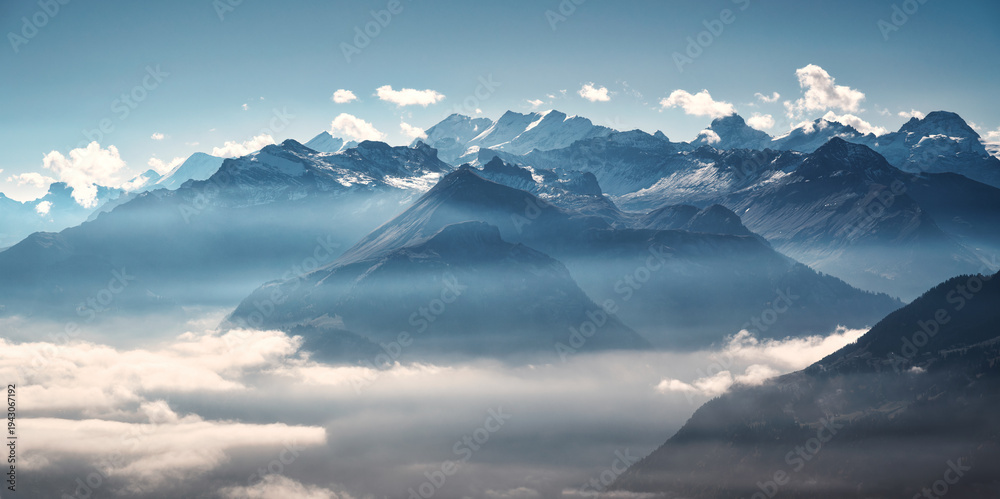 Panoramic aerial view of the Swiss Alps with snow-capped peaks and low ...