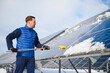 © Serhii - Worker cleaning snow from solar panels in winter