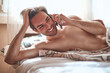 © Teodor Lazarev - Young man happily talking on smartphone in bedroom, enjoying morning communication and connection from the comfort of his bed, smiling during a pleasant phone call