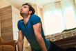 © Teodor Lazarev - Young man practicing yoga bhujangasana or cobra pose at home, stretching his body and looking up for wellness, strength and inner balance