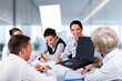 © Gabriel Blaj - A group of people are sitting around a table with a laptop open