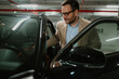 © Zamrznuti tonovi - Businessman entering car in underground parking garage, preparing for daily commute or business travel