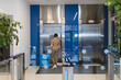 © Serhii - Businesswoman arriving at modern office lobby with luggage
