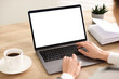 © New Africa - Woman working on laptop at wooden table indoors, closeup