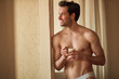 © Teodor Lazarev - Shirtless man enjoying a morning coffee at home, radiating happiness and well-being, embracing a fresh start to a healthy day with a relaxed and confident expression