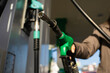© Rabizo Anatolii - Hand holding gasoline nozzle at fuel station close-up. Driver refueling car using gasoline pump
