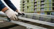 © imagemir - A male technician installs solar panels on a building rooftop, showcasing renewable energy efforts in urban development.