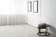 © New Africa - Beautiful pictures on white wall and nesting tables indoors. Interior design
