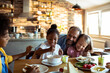 © Davor - Father and children eating breakfast in home kitchen