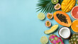 © Chonthicha - Tropical fruit flat lay with papaya, mango, coconut, dragon fruit and citrus on blue background evoking fresh summer mood