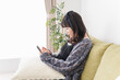 © maroke - 家でスマートフォンを使う若い女性
