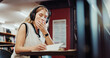 © peopleimages.com - Headphones, yawn or university student writing in library, study notes or streaming music for fatigue. Knowledge, tech or tired woman with notebook to learn, educational podcast or exam preparation