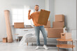© Pixel-Shot - Young man with key and doormat in room on moving day
