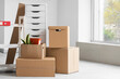 © Pixel-Shot - Cardboard boxes with furniture in office on moving day