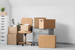 © Pixel-Shot - Chair with chest of drawers and moving boxes in office