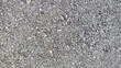 © AmjadRosli - Close-up view of rough asphalt surface with small grey and white stones creating a detailed and rugged texture background.