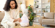 © Pixel-Shot - Young African-American woman with air humidifier on table at home