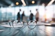 © Lady O - Glasses on a table in an office with business people meeting. a business team discussing a project and working together, with a blurred background.