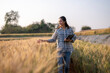 © Wasana - Woman farmer walking analyzing wheat crop with tablet