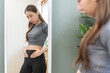 © KMPZZZ - Excess weight gain, overweight asian young woman touching stomach wearing fit body clothes, dissatisfied about her body shape from fat around waist. Obese getting belly fat, diet, weight loss concept