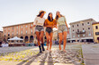 © Xavier Lorenzo - Multiracial young female friends laughing in city square. Joyful women sharing fun moments during summer vacation. Friendship and lifestyle concept.