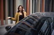 © Parichat - Woman feeling stressed having trouble with her car while making a phone call outdoors