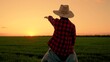 © Victoriia - Child boy play together father in green field. Dad son point toward sunset. Happy family. Kid boy in hat sits on father's shoulders. Family trip through nature park. Child shows dad sunset with hand