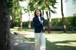 © Parichat - Smiling asian woman holding laptop walking in park