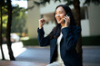 © Parichat - Young businesswoman celebrating success on outdoor phone call