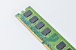 © dimas830 - Close-up of a green computer RAM module with black memory chips on a white background