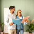 © Lisa - Couple, homeowner and room color paint choice together for house wall renovation and decoration. Young woman and man in relationship deciding on home repair and remodeling interior palette.
