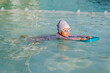 © geargodz - preschool child girl learning to swim with board in swimming pool