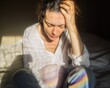 © Breezze - Pregnant woman sitting on a bed with hand on head feeling tired or stressed, moody indoor scene capturing maternity struggle and mental health concept for healthcare