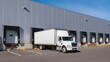 © Hypnyo - Delivery truck parked at warehouse loading docks, industrial distribution center exterior, logistics and supply chain operations