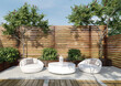 © Victor zastol'skiy - Modern backyard lounge area with white furniture. 3D rendering of outdoor patio with wooden fence