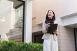 © crizzystudio - Woman holding tablet inspecting property outdoors smiling