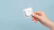 © Dmytriy - Sexual health care and disease protection: unopened condom in hand on a blue background