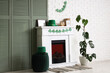 © Pixel-Shot - Interior of festive room decorated for St. Patrick's Day celebration with clovers garland, folding screen and leprechaun's hat on fireplace